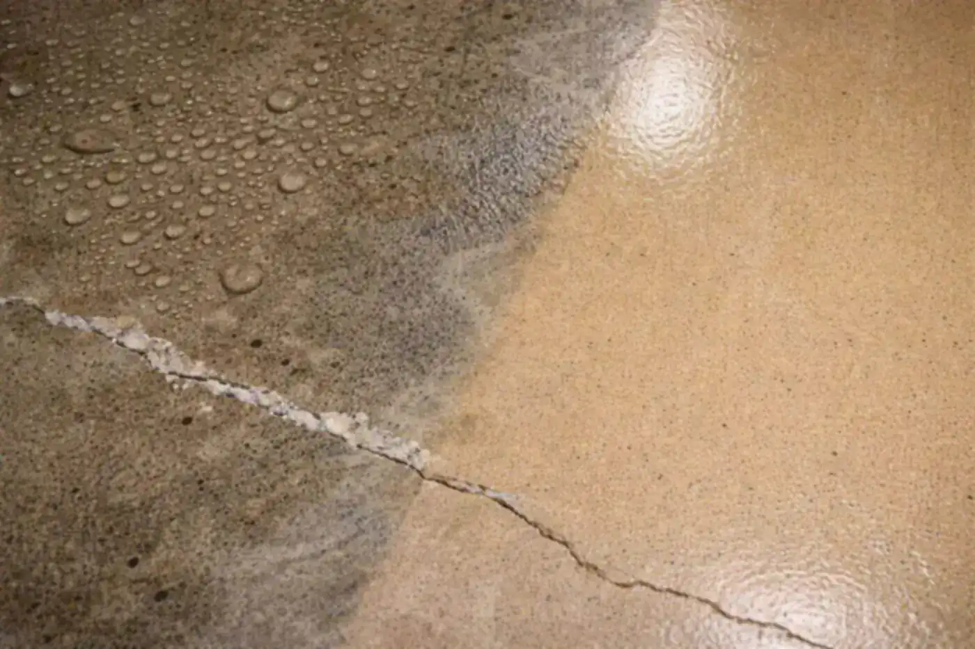 Water beading on a coated slab beside a crack in Houston